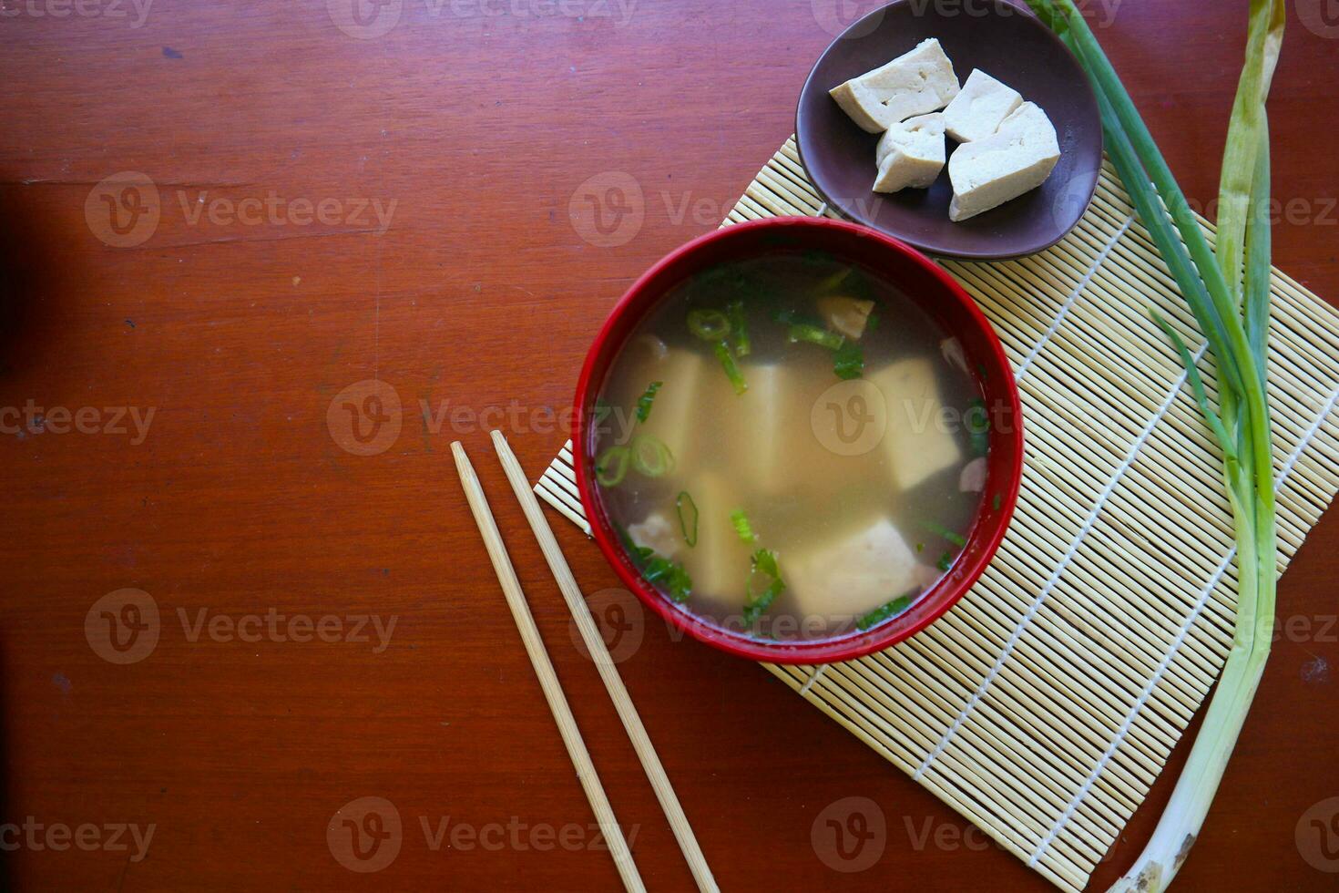 miso soup or Japanese miso soup in bowl on the table. Japanese cuisine in the form of soup with dashi ingredients, tofu, seafood, vegetables, and topped with miso to taste photo