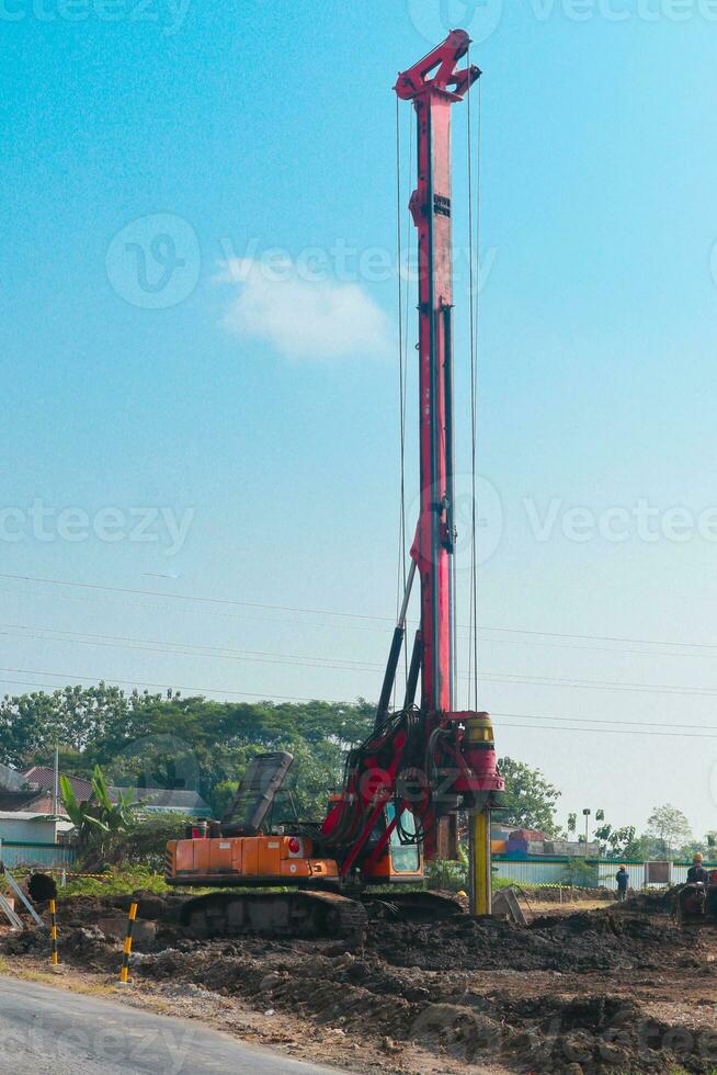 Powerful hydraulic machine drilling rig on a construction site. Installation of bored piles by drilling. Pile foundations. Drilling in the ground photo