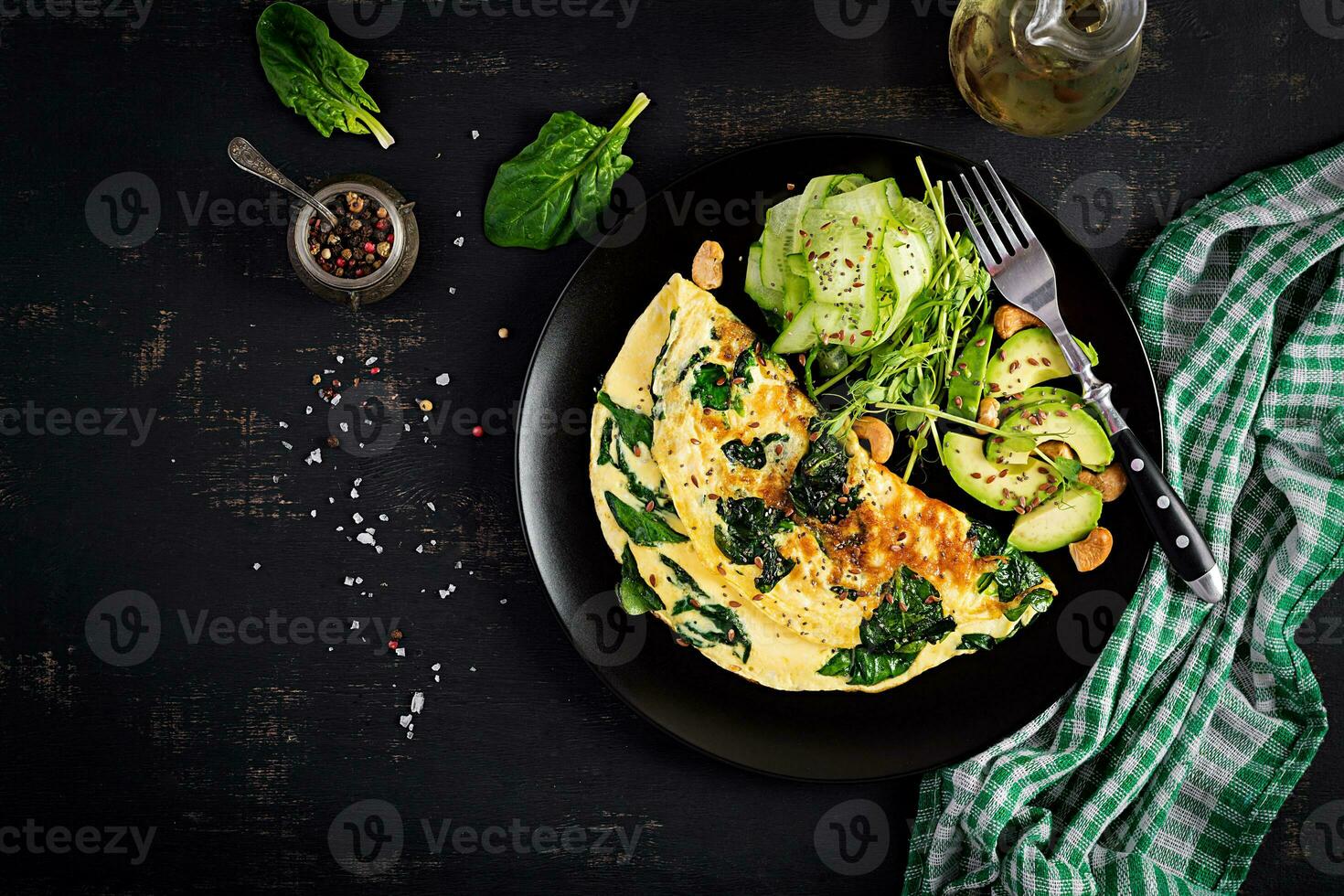 Ketogenic, paleo diet breakfast. Omelette with spinach and avocado, cucumber. Top view, copy space photo