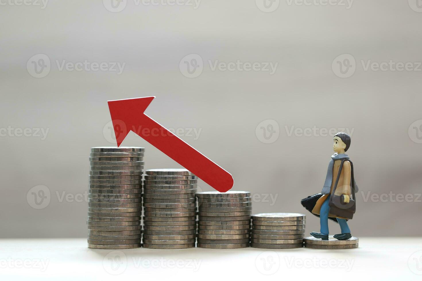 Business man standing on stack of coins money and red arrow graph on natural green background, investment and business concept photo