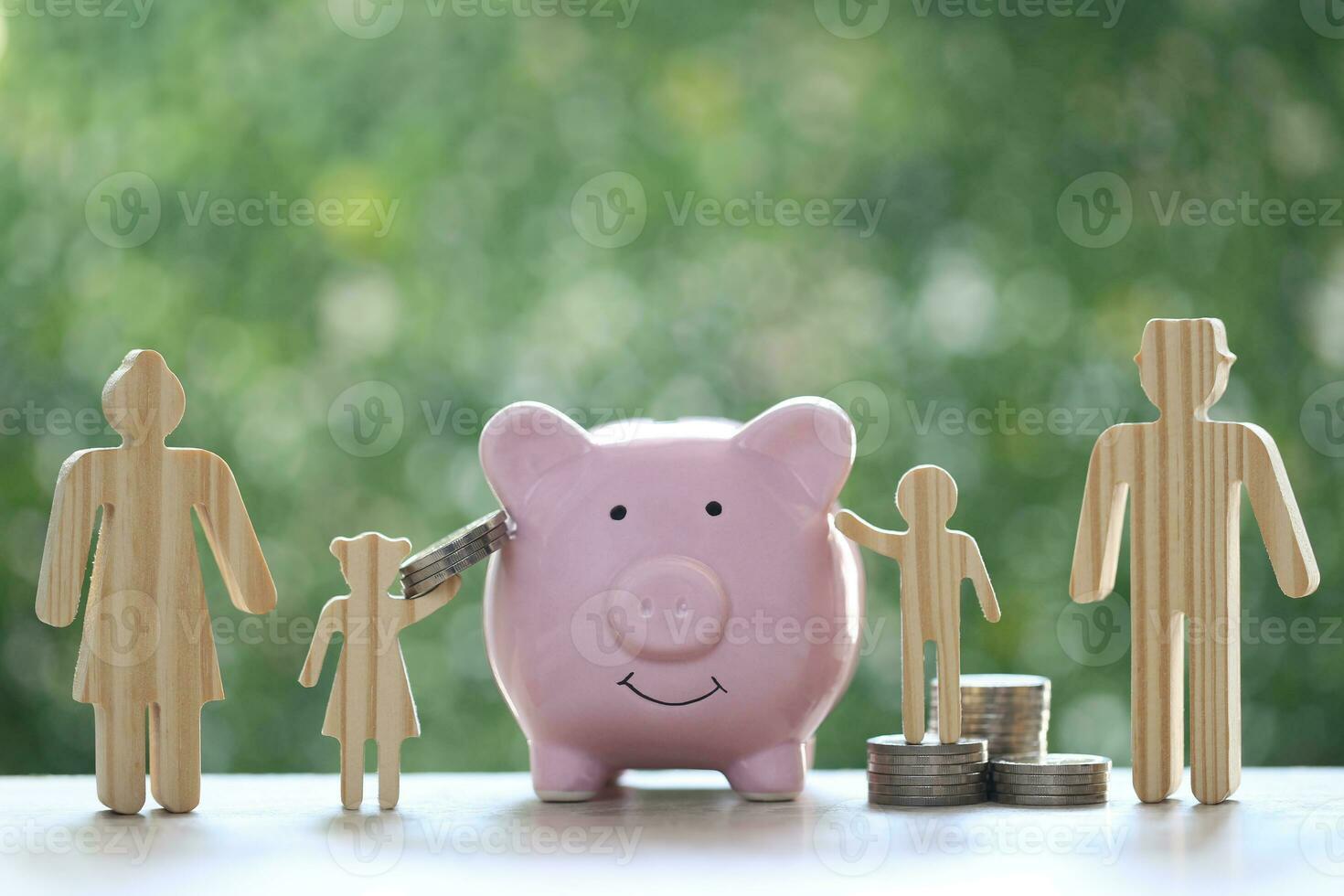 Model family with piggy bank and stack of coins money on natural green background,Save money for prepare in future and family finance concept photo