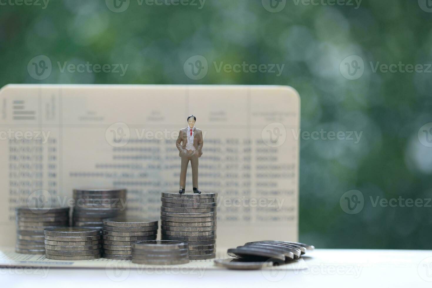 Business man standing on stack of coins money on natural green background, investment and business concept photo