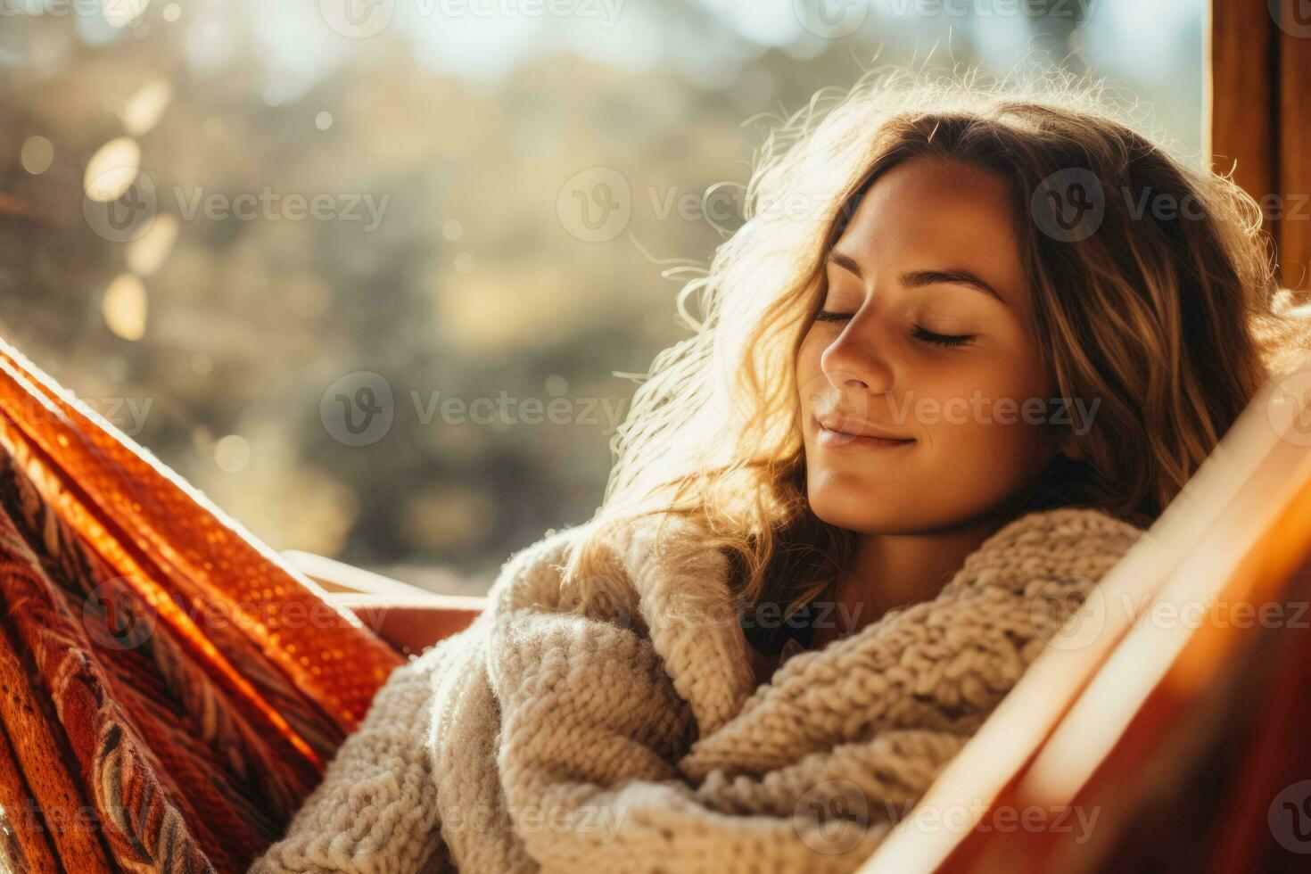 Person snuggling up with a blanket on a hammock in a cozy sweater