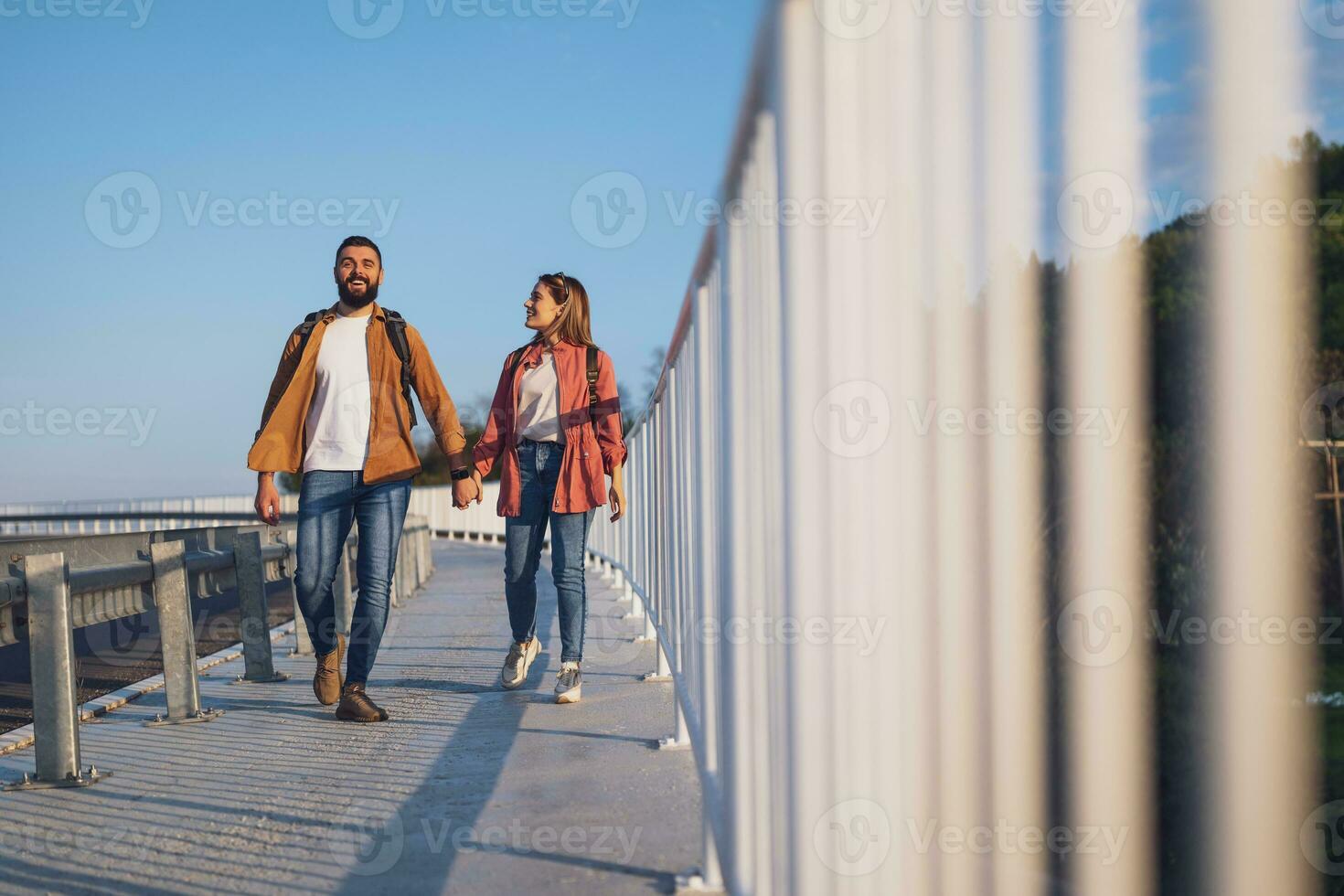 contento Pareja participación manos y caminando en peatonal pasarela turistas son Turismo en el ciudad. foto