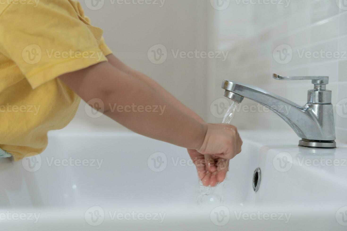 pequeño niño manos lavar con jabón burbujas y enjuague con limpiar agua a evitar y detener el untado de gérmenes después espalda a hogar, virus o COVID-19. bueno salud y bueno personal higiene, virus, bacterias foto