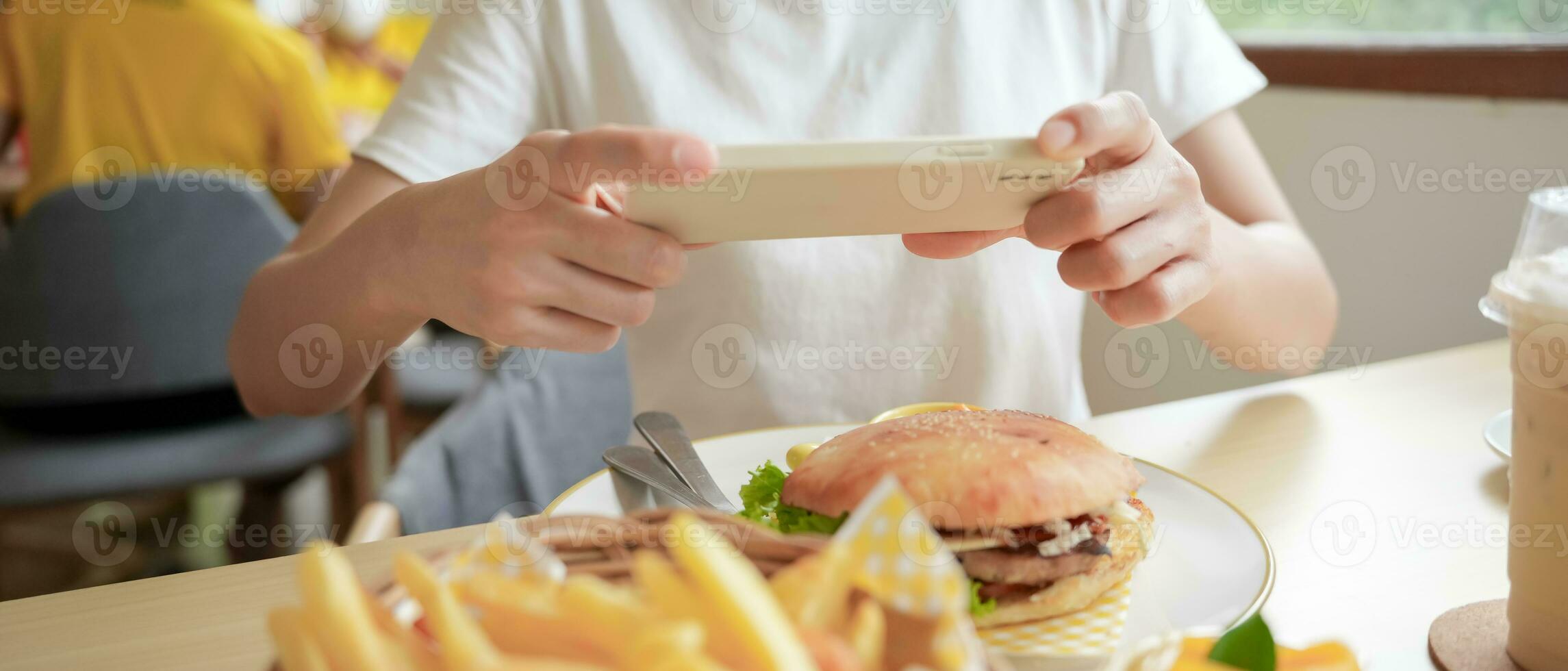 restaurant owner takes a picture of the food on the table with a smartphone to post on a website. Online food delivery, ordering service, influencer, review, social media, share, marketing, interest. photo