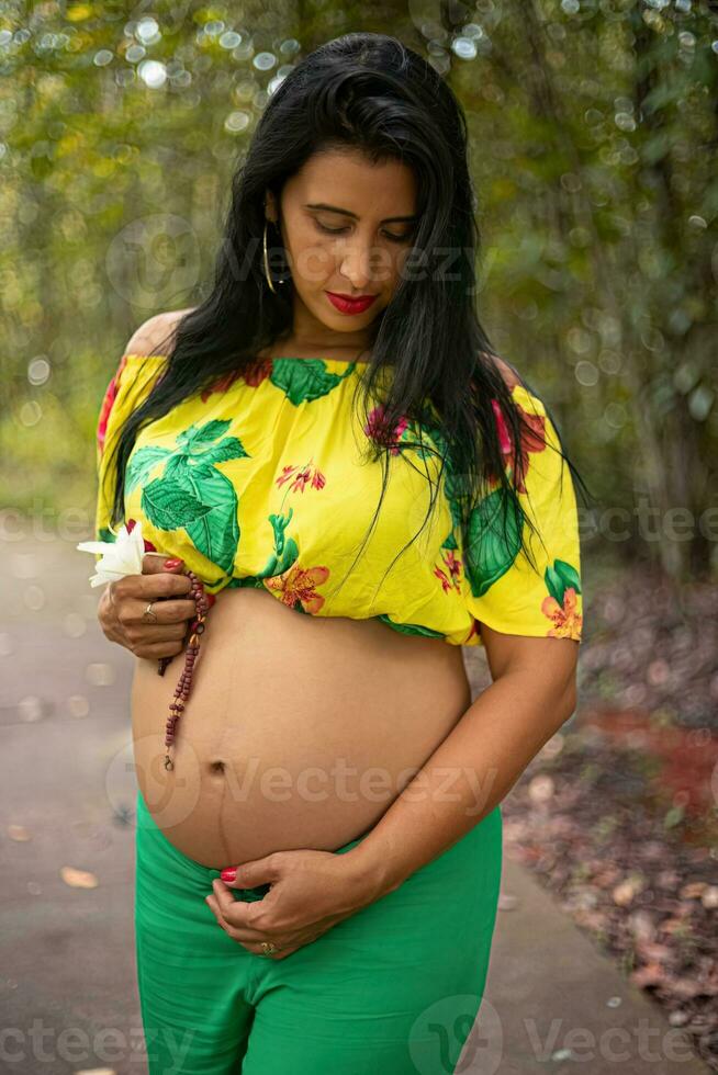 Pregnant woman posing in a park photo