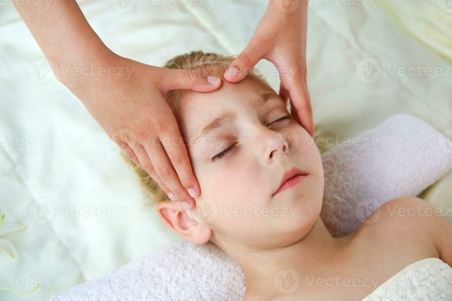 Masseur doing face massage to child. photo