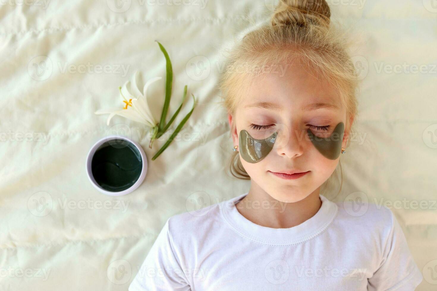 Beautiful girl with hydrogel patches under the eyes. Top view. photo
