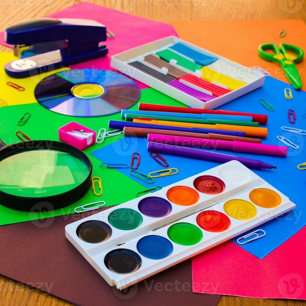 Stationery objects. School and office supplies on the background of colored paper. photo