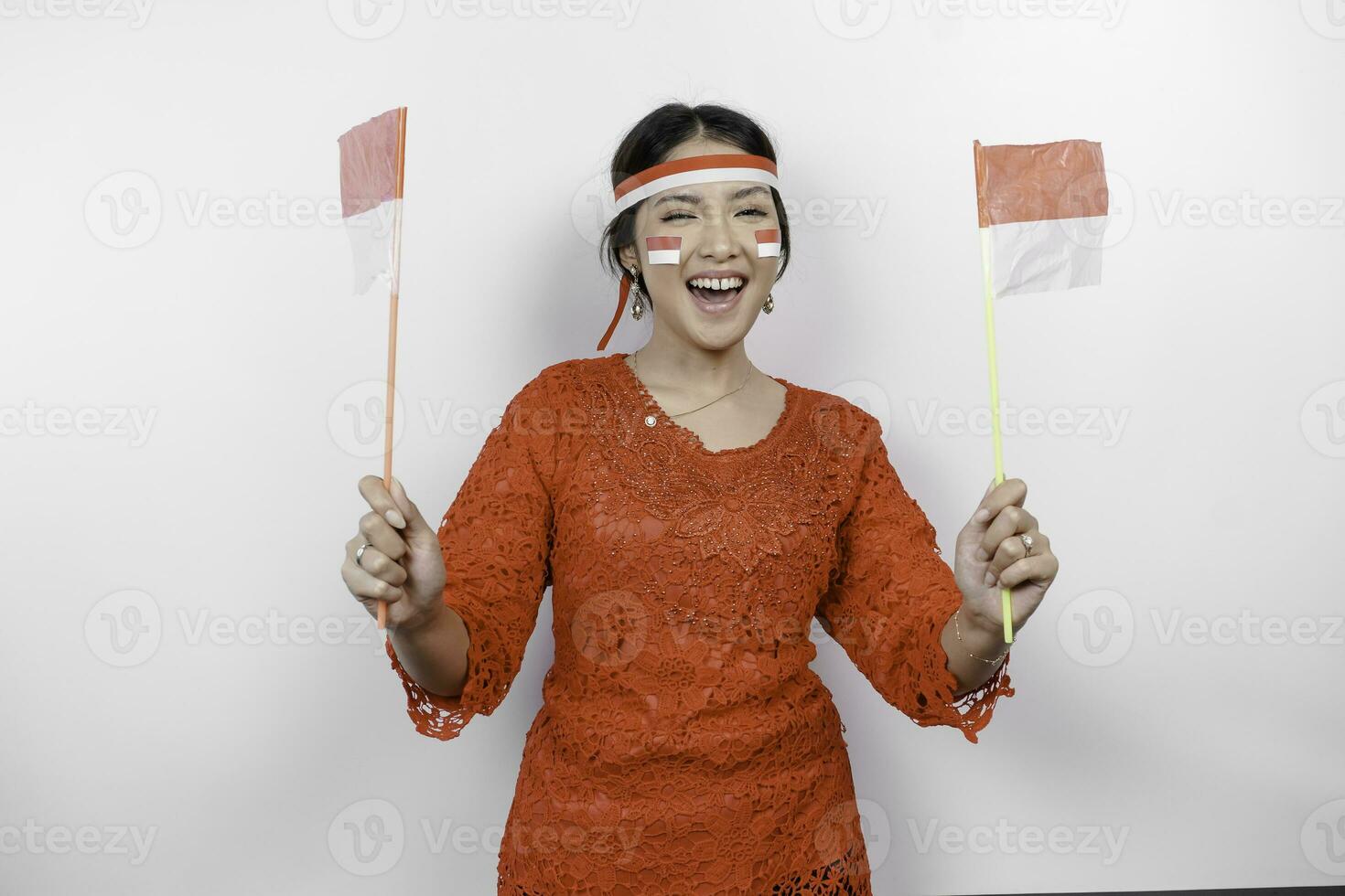 contento sonriente indonesio mujer vistiendo rojo kebaya y venda participación de indonesia bandera a celebrar Indonesia independencia día aislado terminado blanco antecedentes. foto