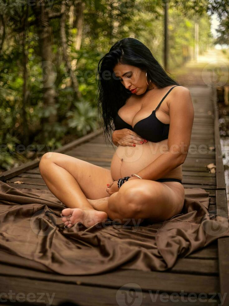 Pregnant woman posing in nature photo