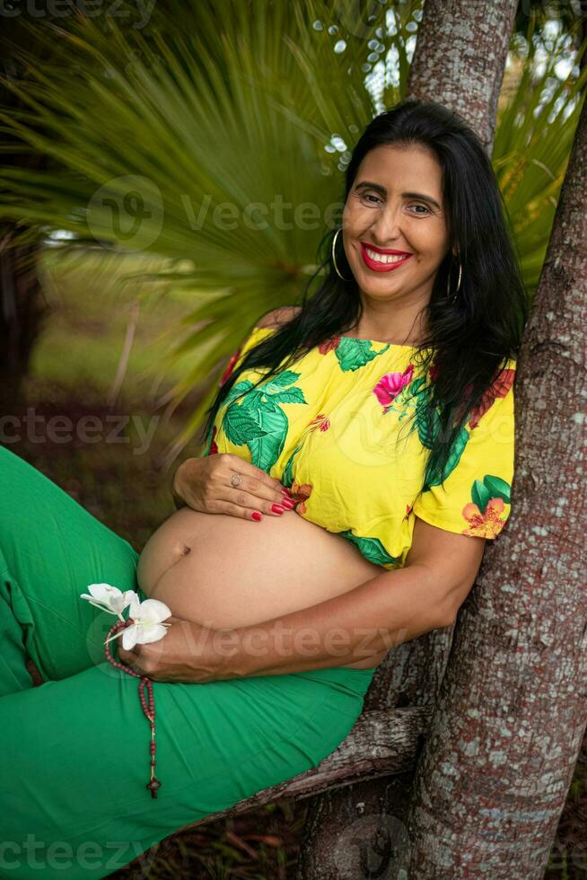 embarazada mujer posando en un parque foto