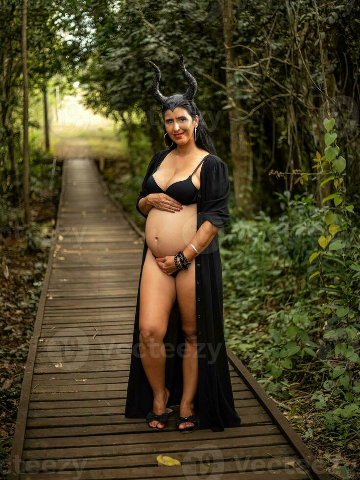 Pregnant woman posing in nature photo