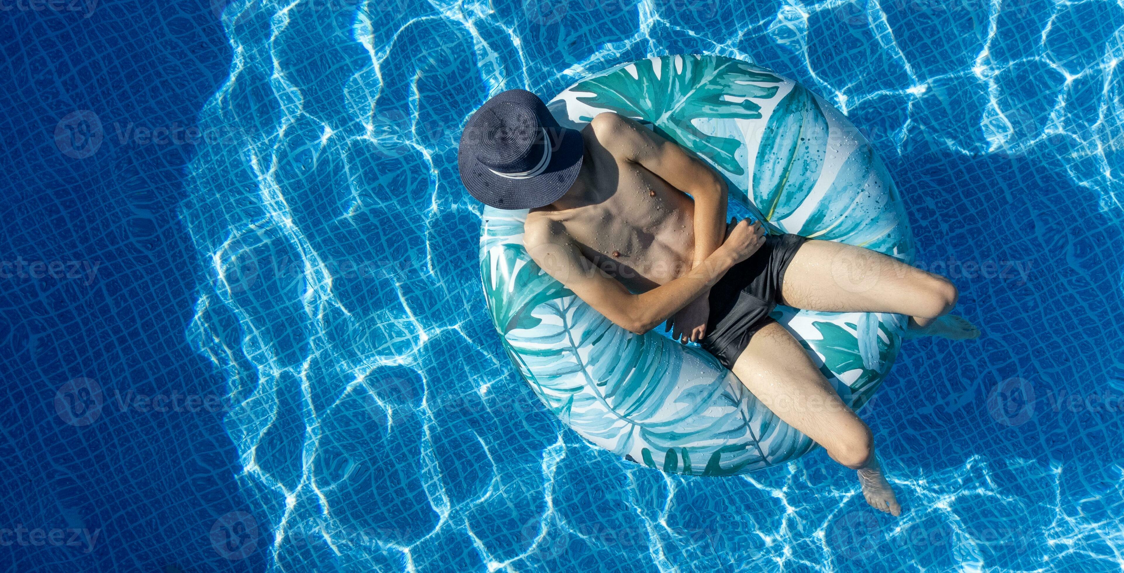 Man swimming on swim ring in the pool. Person swimming in the pool