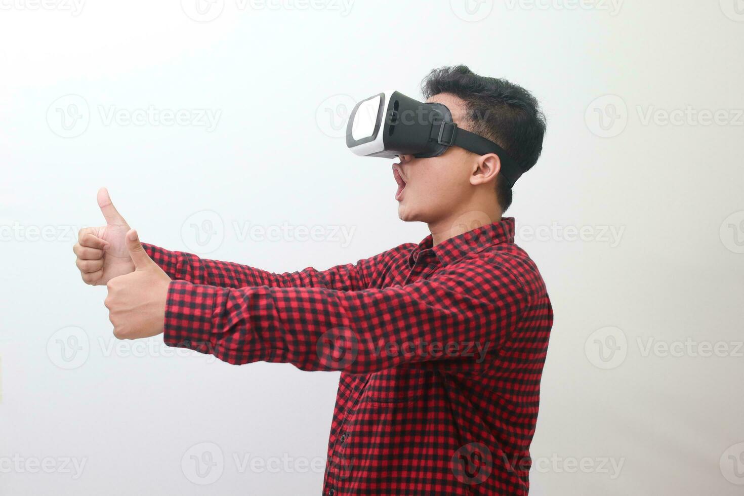 retrato de asiático hombre en rojo tartán camisa utilizando virtual realidad vr lentes y demostración pulgar arriba mano gesto. aislado imagen con Copiar espacio en blanco antecedentes. foto