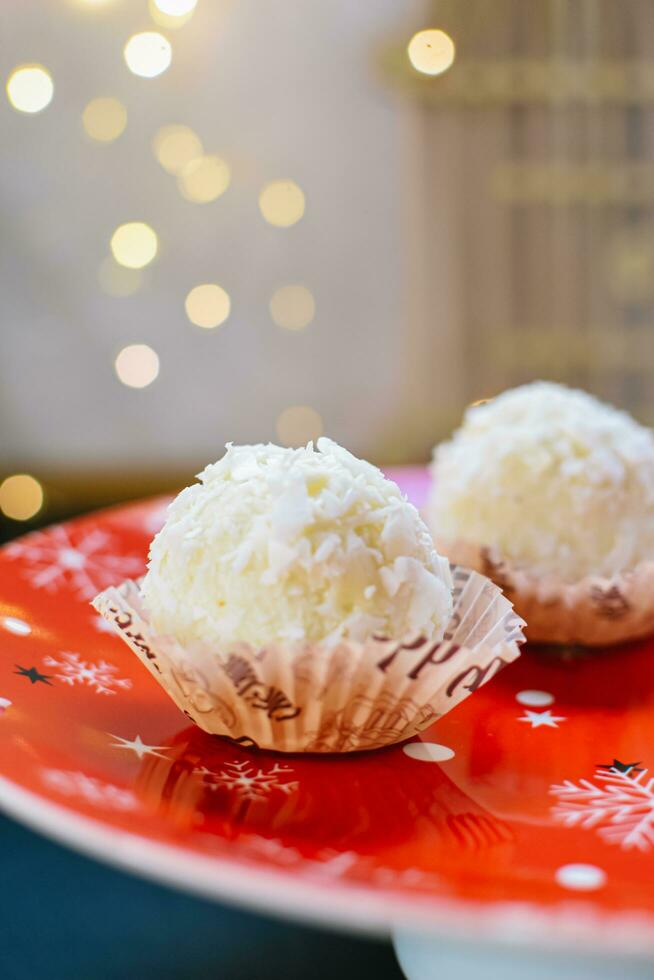 Homemade Raffaello and New Year's mood on a plate. concept of the new year photo