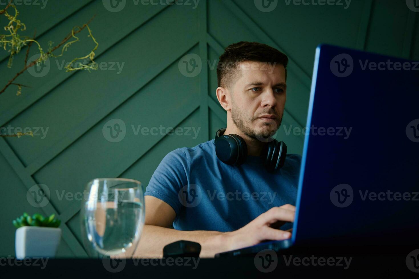 Man working remotely at home office with laptop photo