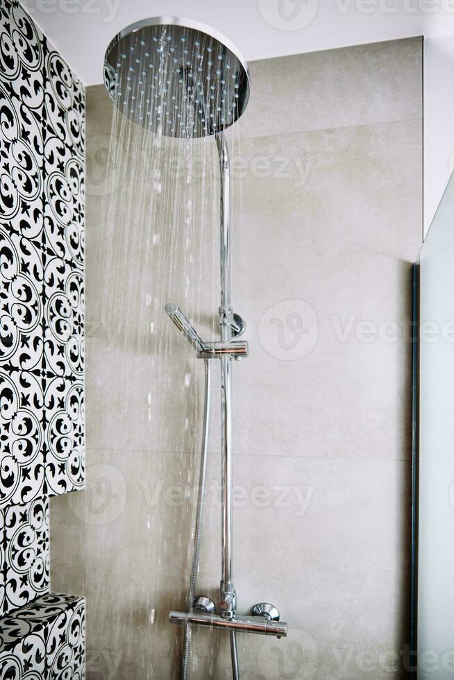 Water flowing from shower head in bathroom photo