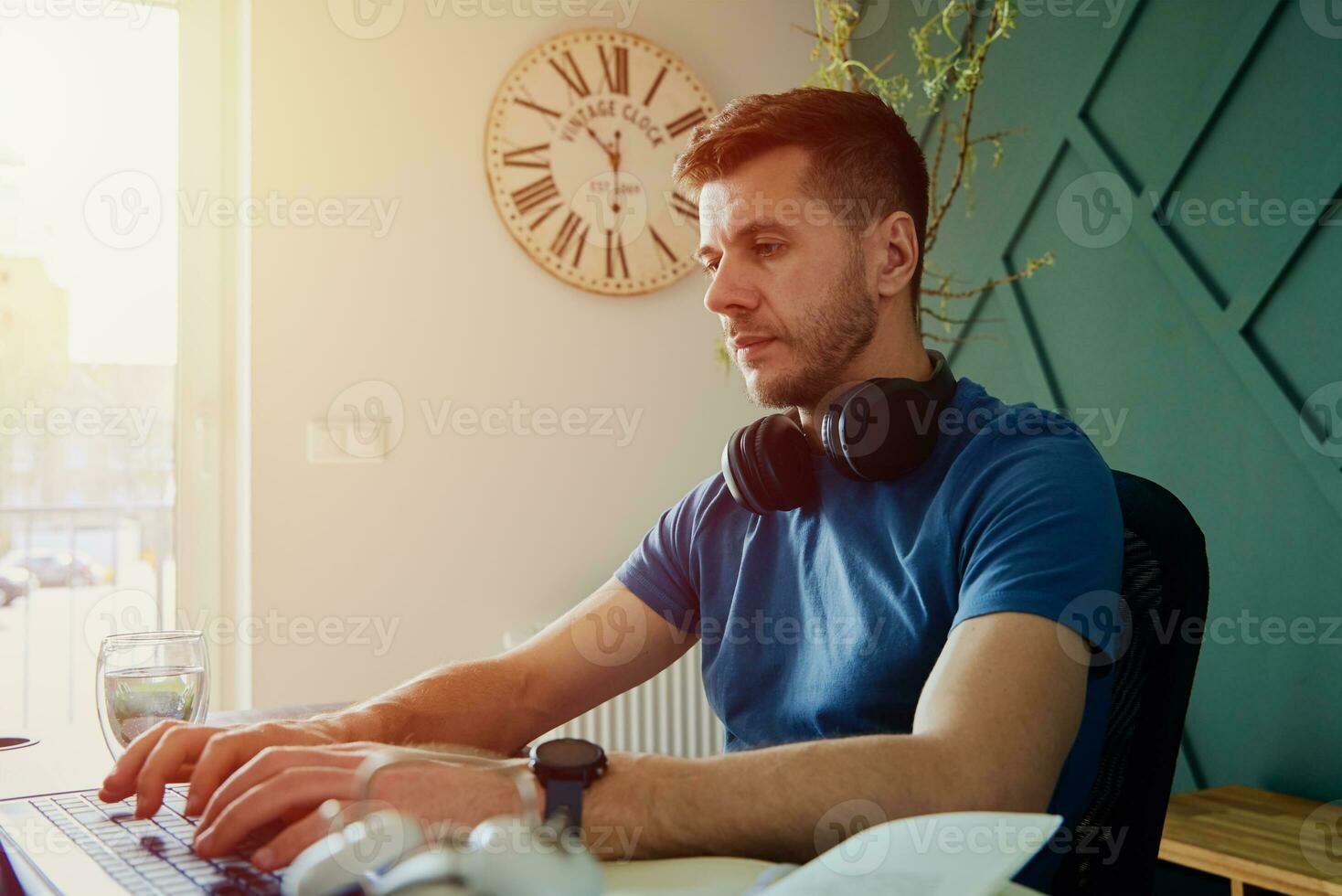 Man working remotely at home office with laptop photo