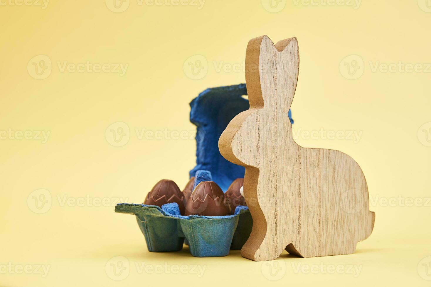 Happy Easter decoration, Wooden rabbit and eggs on yellow background photo