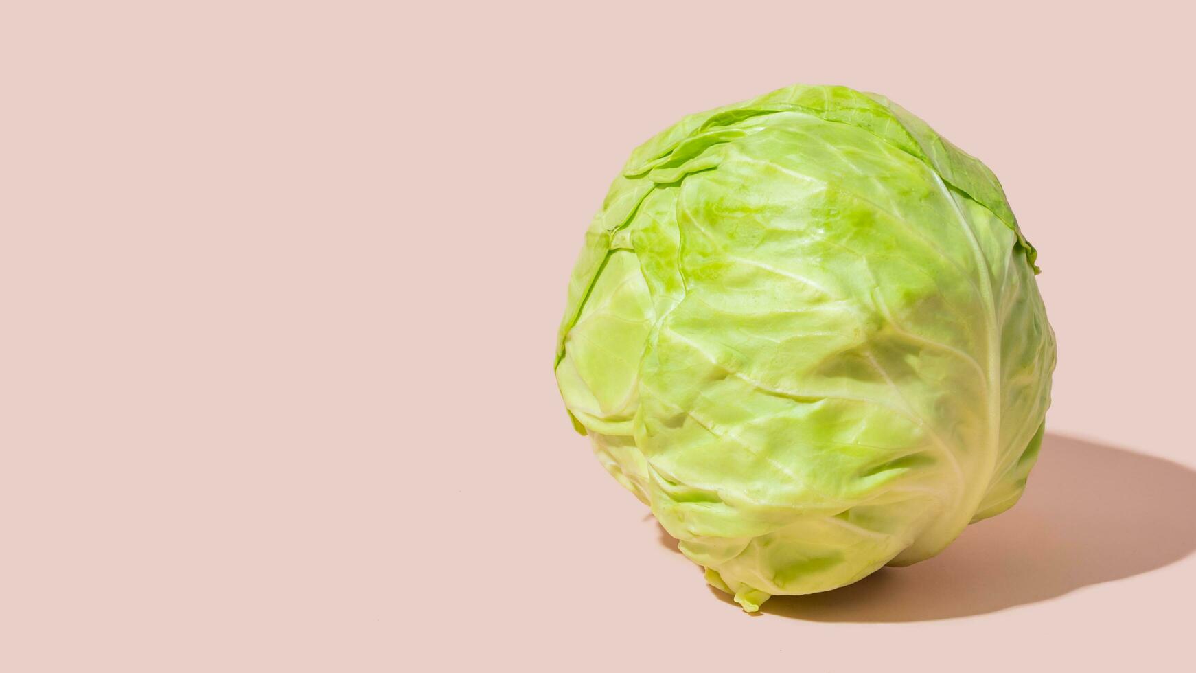 Ripe young green cabbage isolated on pink background, copy space photo