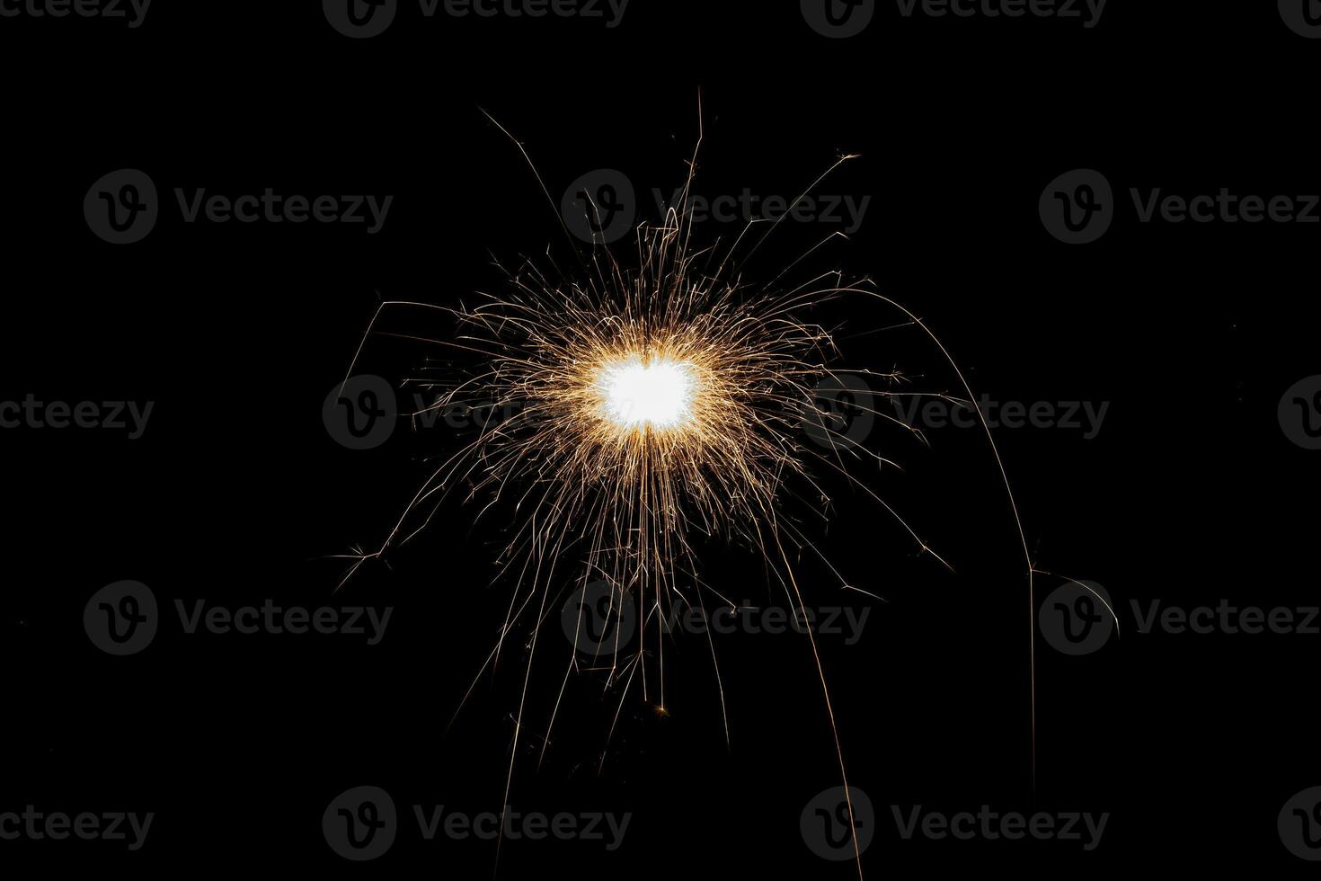 Burning sparkler isolated on black background. Fireworks theme. Light effect and texture. photo