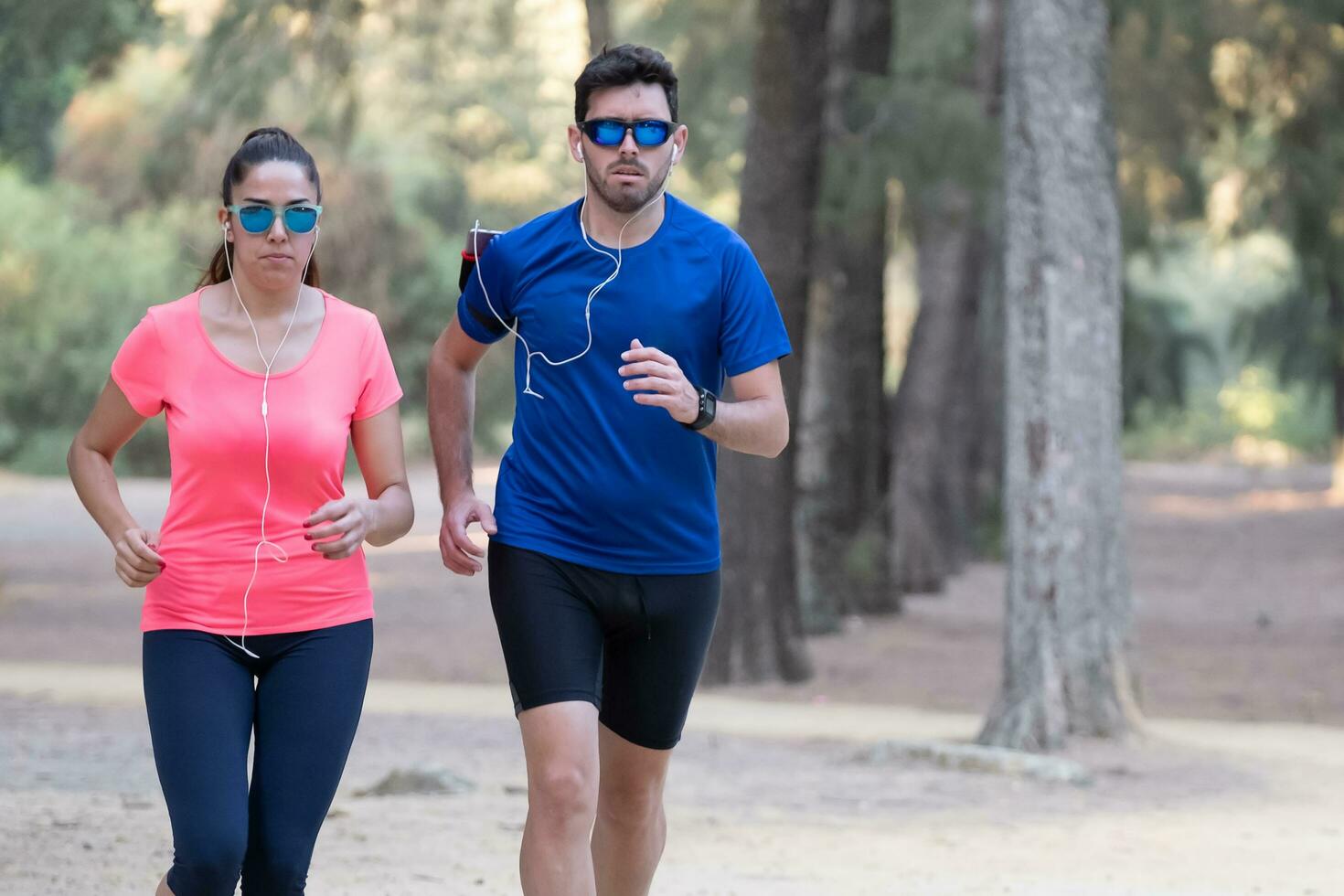 Pareja de corredores hacer ejercicio en un parque y escuchando a música. foto