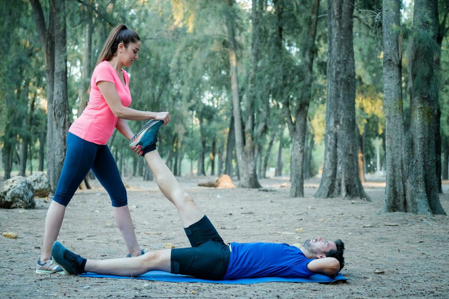 Caucasian couple doing stretching exercises in a park photo