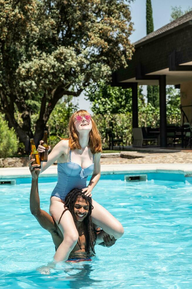 afroamericano hombre y blanco mujer jugando en un piscina. foto