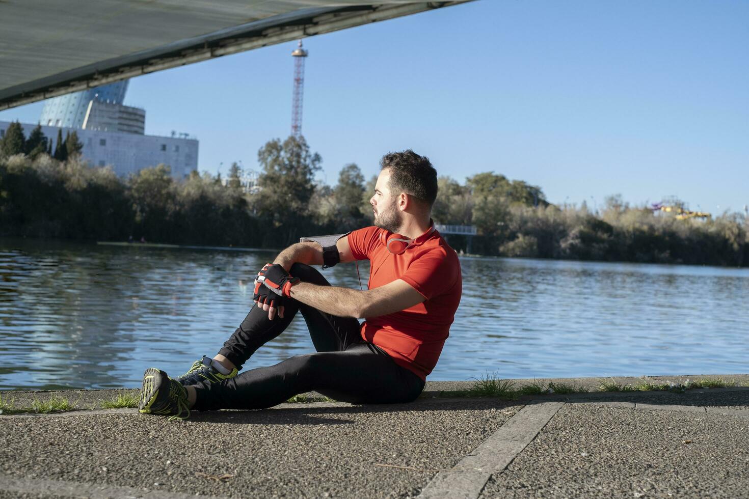 un de cerca Disparo de un joven masculino en Deportes disfraz sentado en el cuerpo de el río foto