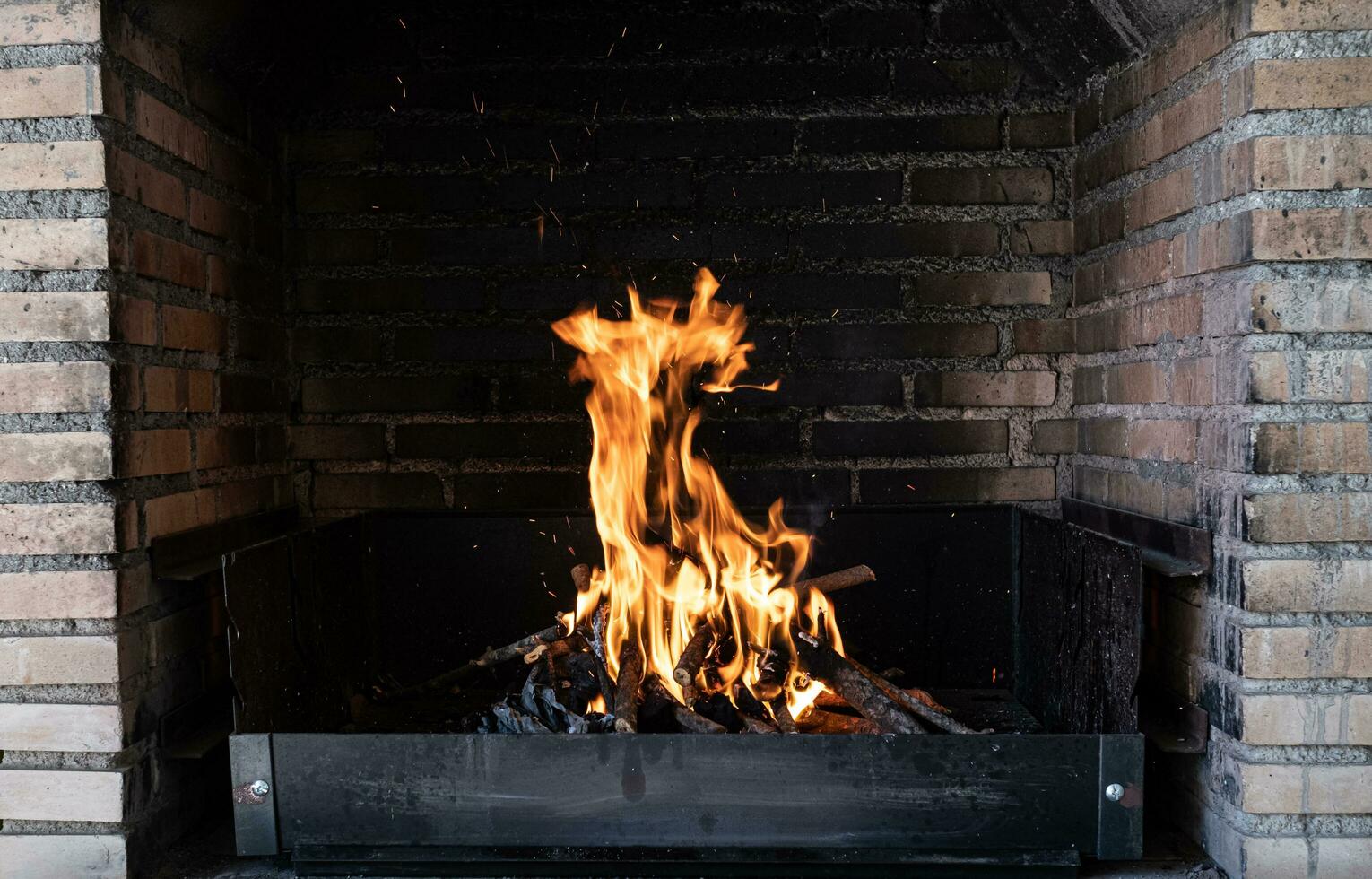 burning fire for a barbecue inside brick walls photo