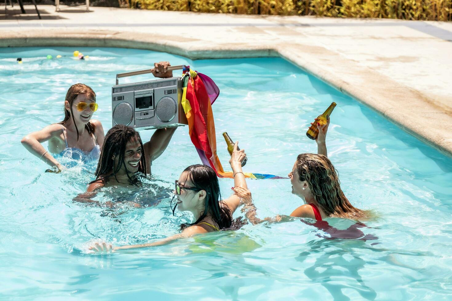 young people of different ethnicities drinking party beer in a swimming pool photo