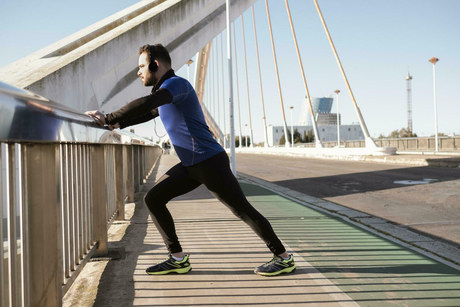 man stretching on a bridge railing. sport concept photo