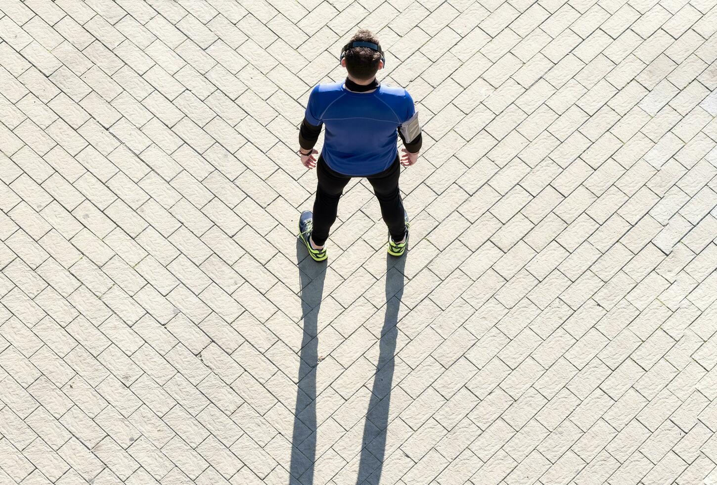 ver desde encima de un joven hombre trabajando fuera escuchando a música. concepto de sano viviendo. foto