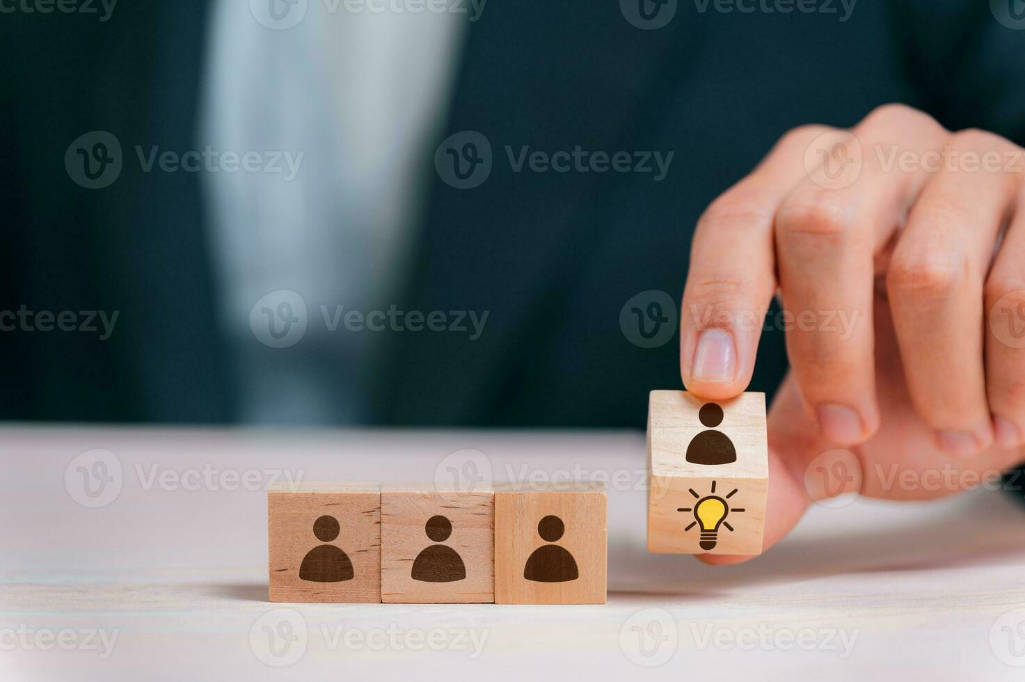 Leader choosing the best new idea with light bulb icon on wooden blocks. Explore creative design, solutions, strategy reviews. Inspiring innovation and teamwork. photo