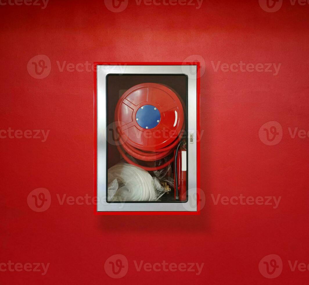 Fire extinguisher for fire protection on red wall photo