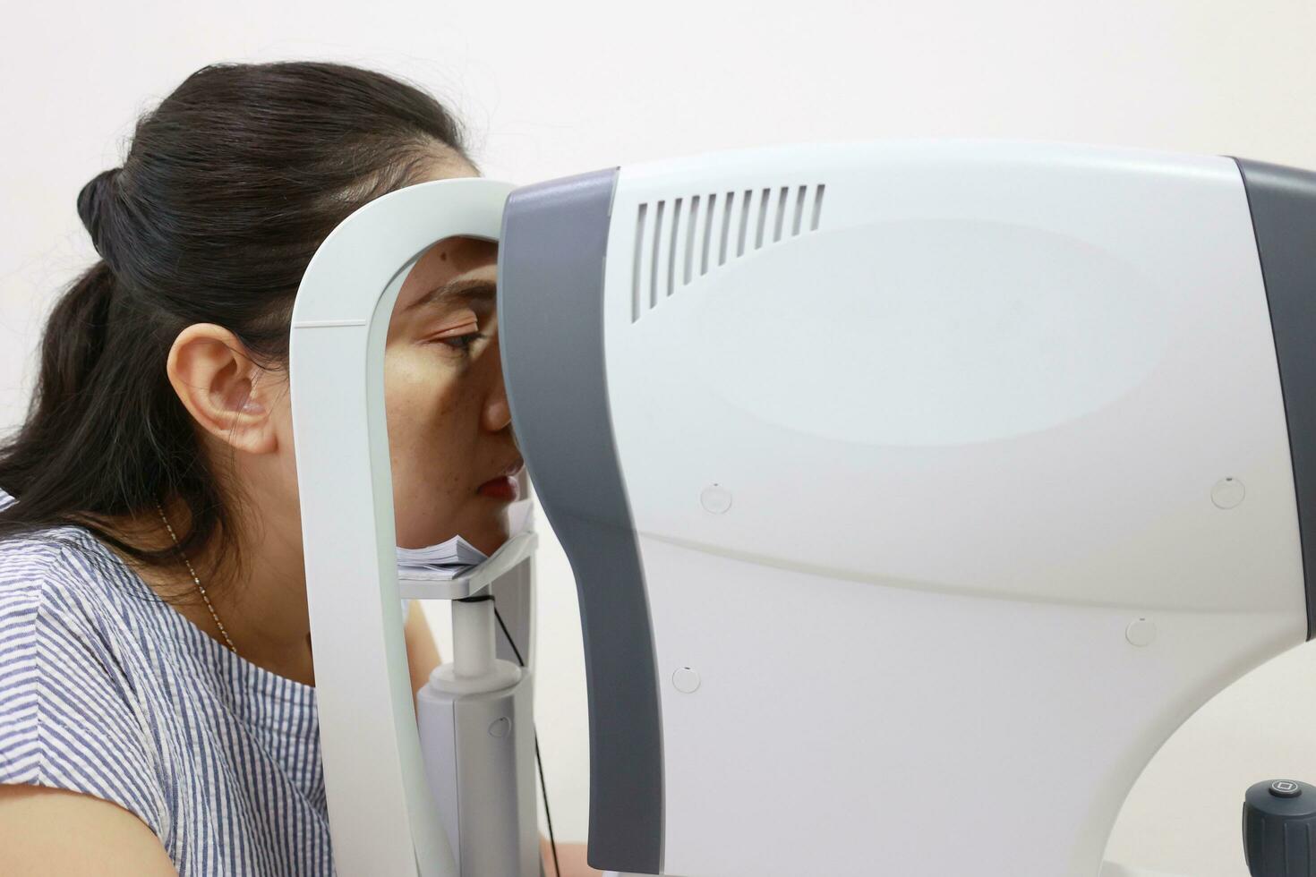 Eye exam concept, woman eye test in clinic, beautiful girl wearing eyeglass on blur optical shop background photo