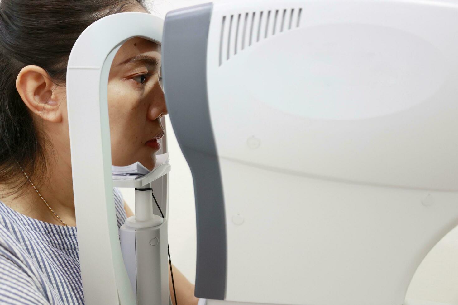 Eye exam concept, woman eye test in clinic, beautiful girl wearing eyeglass on blur optical shop background photo