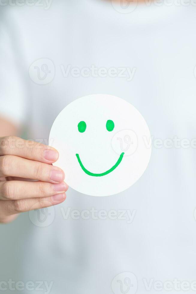 Woman show Happy Smile face paper, Mental health Assessment, Psychology, Health Wellness, Feedback, Customer Review, Experience, Satisfaction Survey, Positive Thinking and World Mental Health day photo