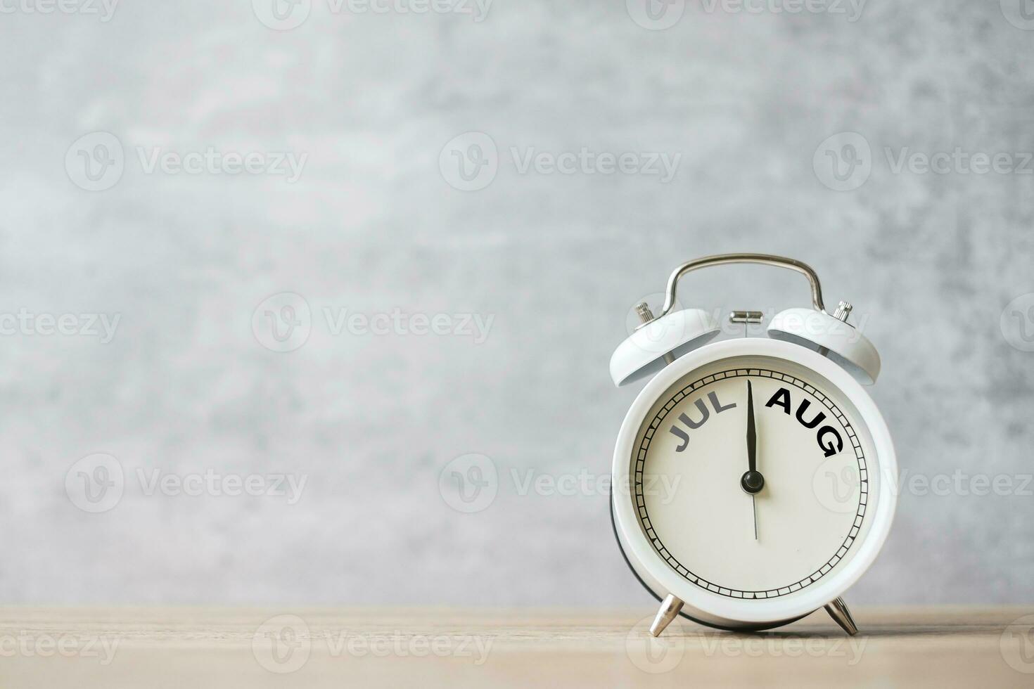 Hello August  Changed from July month with vintage alarm clock on table background. Calendar, Monthly, New Start, Resolution, Goals, Plan, Action and Mission Concept photo