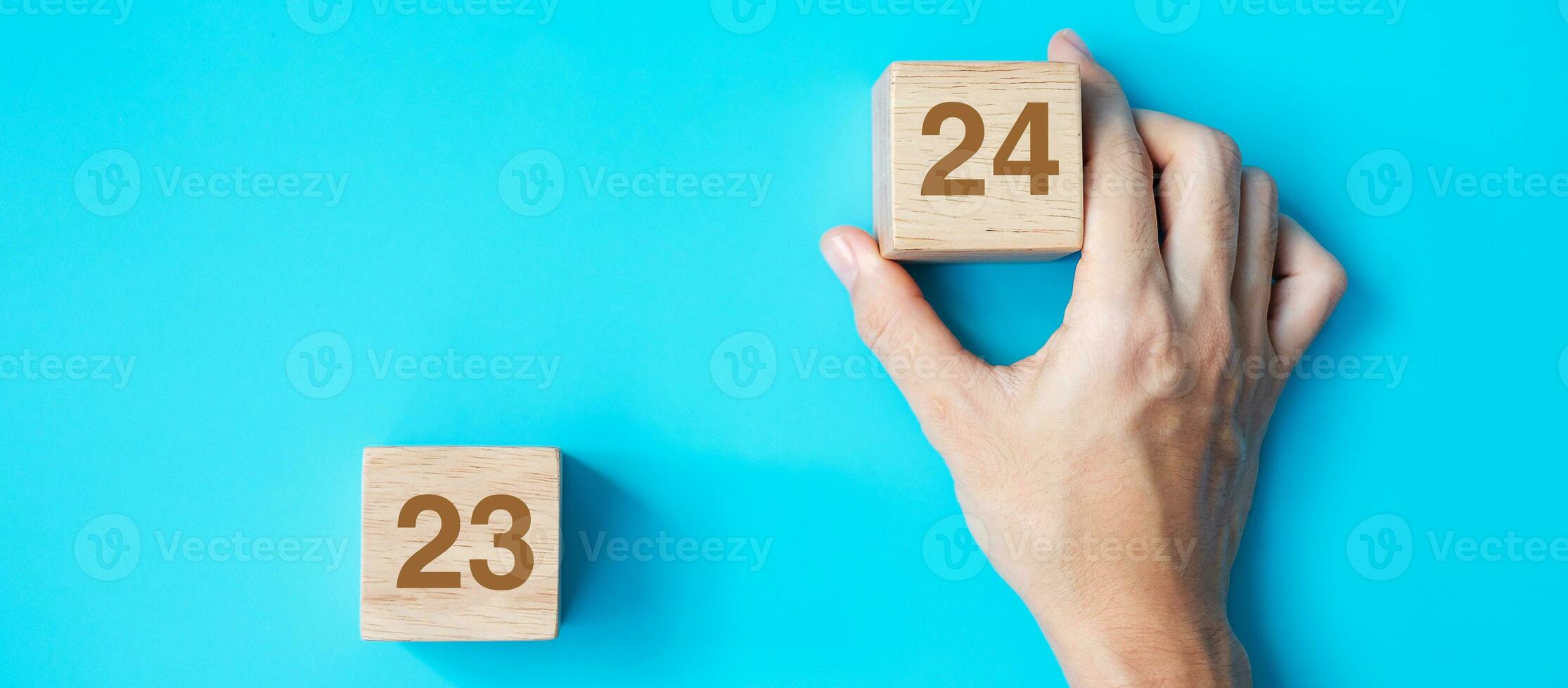 hand holding wooden cube block with 2024 text on blue background. Resolution, plan, review, goal, start and New Year holiday concepts photo