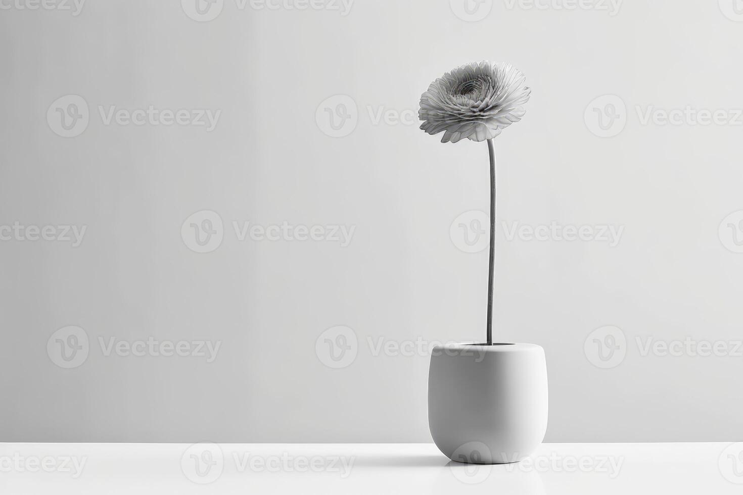 A monochromatic photograph of a single flower in a minimalist vase against a plain background. photo