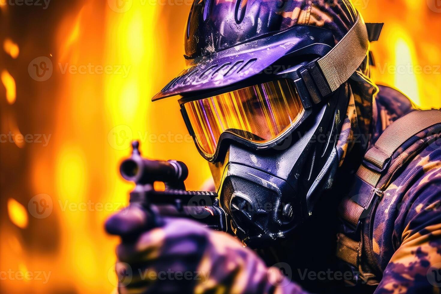 Close-up shot of a male paintball player pointing his paintball gun at the camera. photo