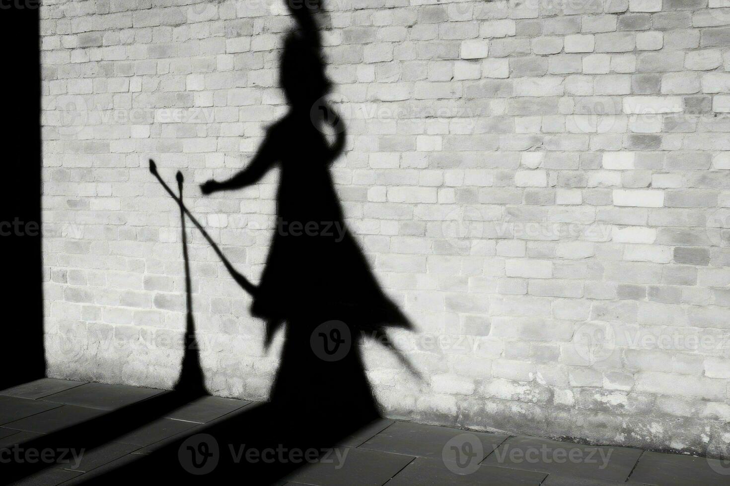 A witch's silhouette being cast on a wall, with the prominent shadow of a broomstick suggesting flight.  Generative AI photo