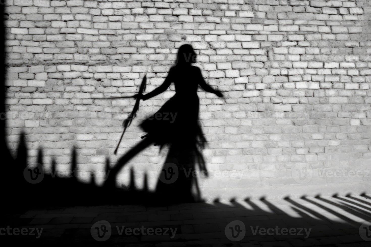 A witch's silhouette being cast on a wall, with the prominent shadow of a broomstick suggesting flight. photo