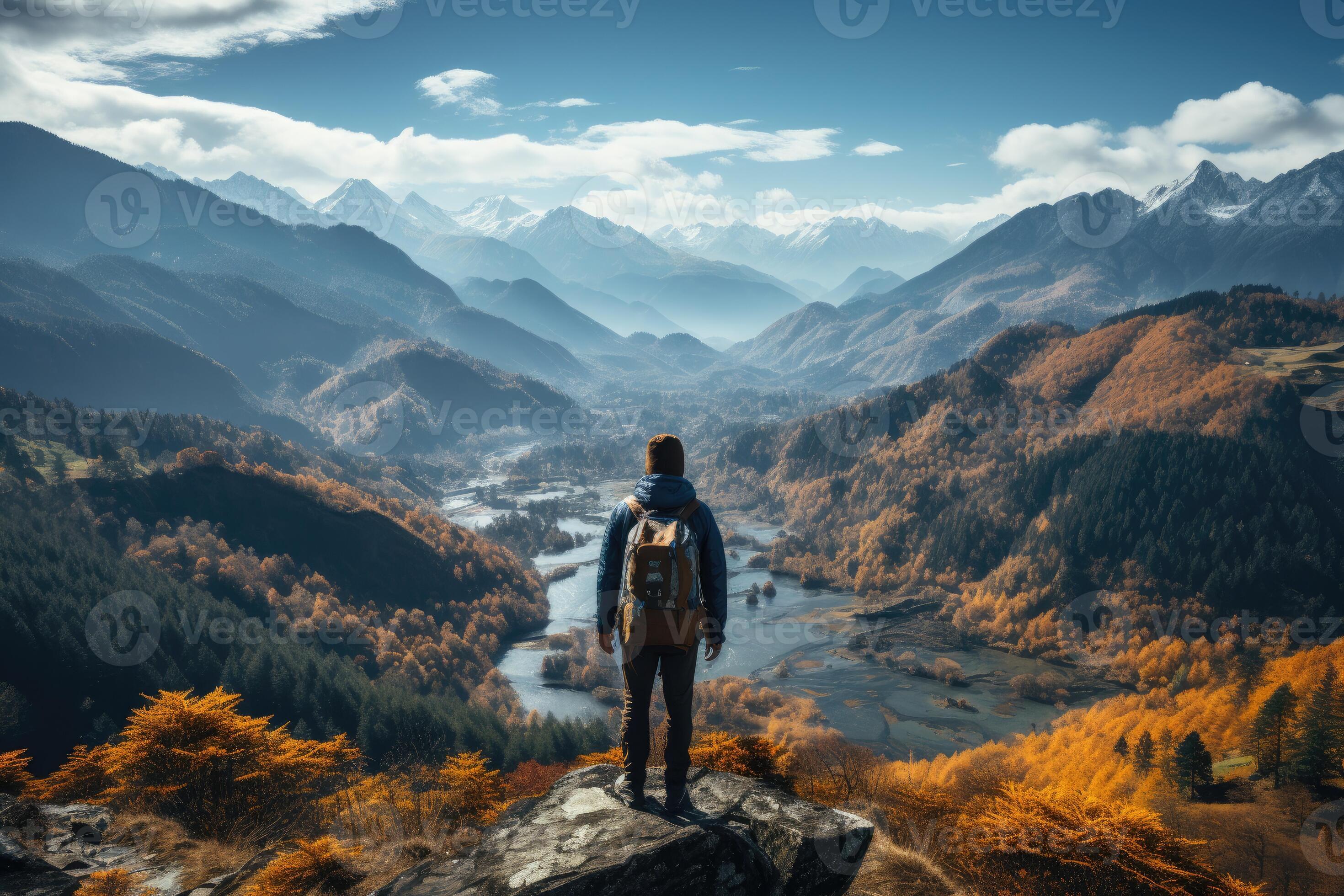 Hiker at a mountain peak overlooking a breathtaking view. 26809321(00)
