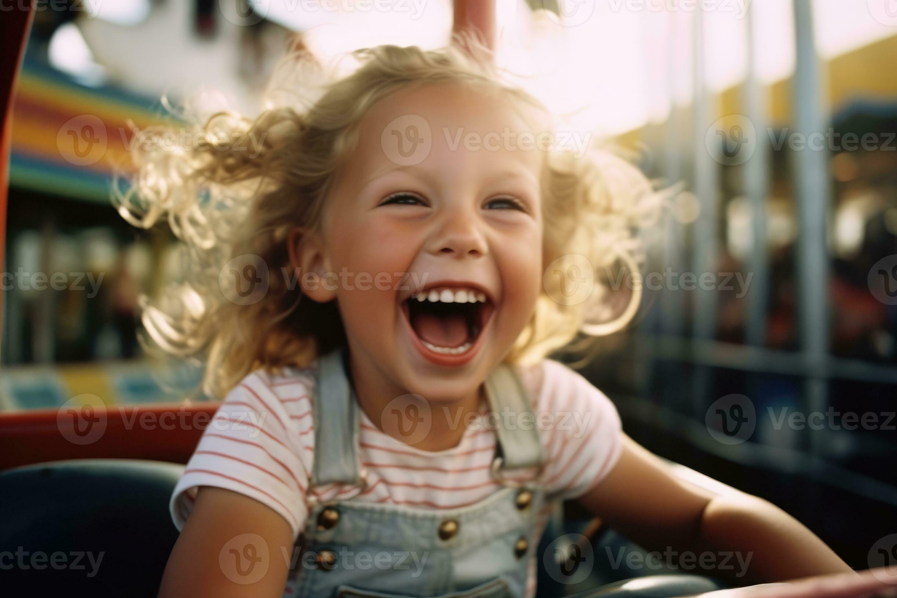 Close-up shot of a little girl laughing and having fun at the amusement ...