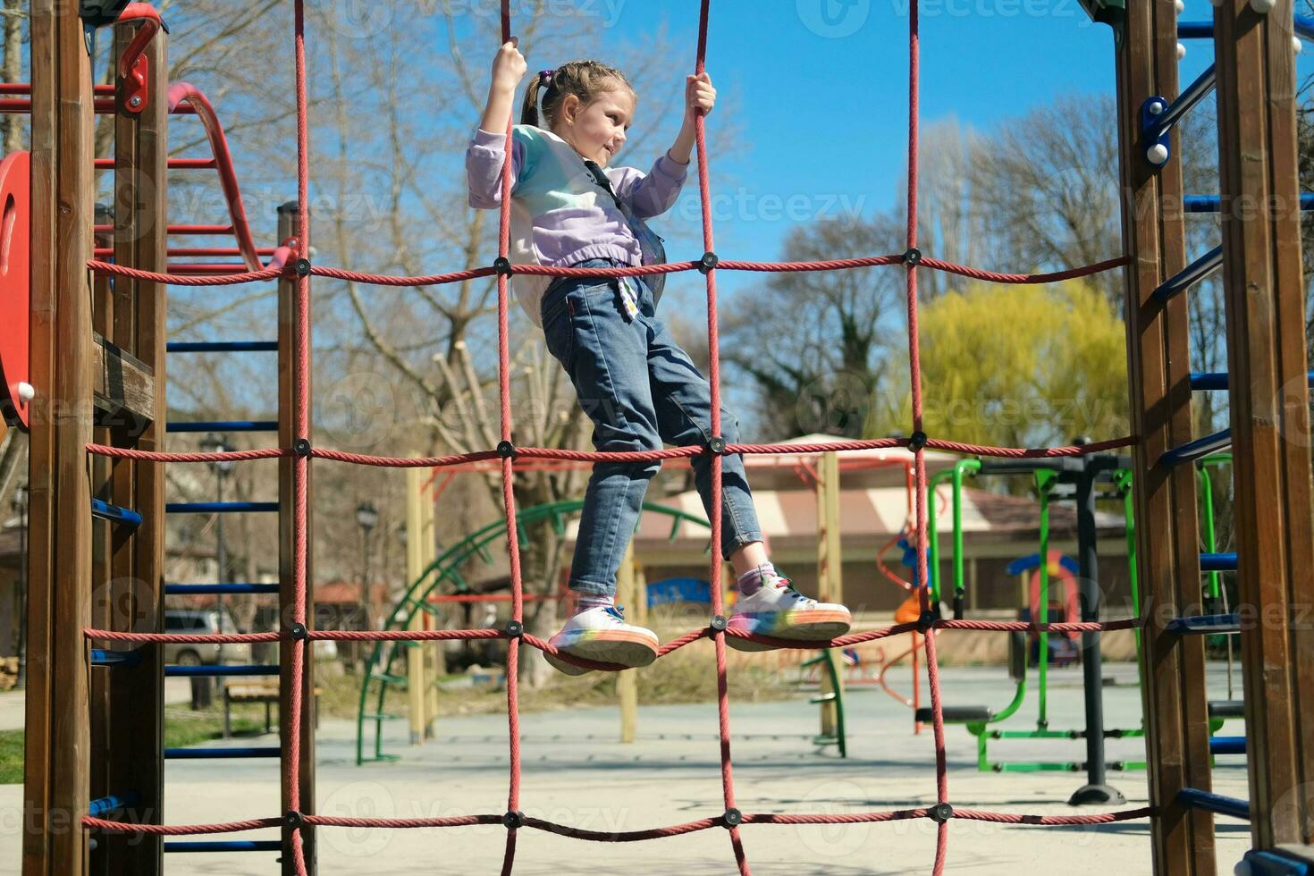un niño sube en un cuerda patio de recreo al aire libre en un parque foto