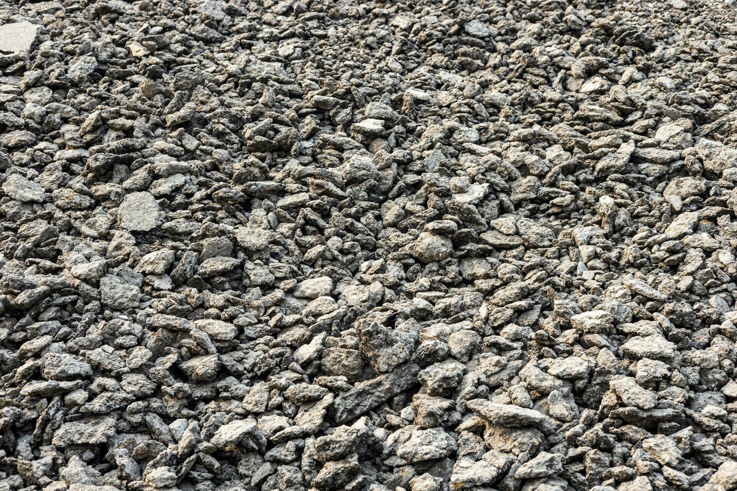 Heaps of bits and pieces of asphalt stones taken from demolished roads. photo